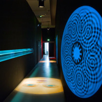 [Couloir de l'exposition Lanterne magique et film peint - 400 ans de cinéma (Paris) avec projections murales et au sol - Photographie Stéphane Dabrowski]